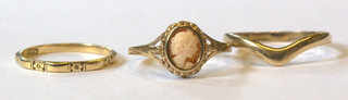 A lady's dress ring set an oval cameo, a 9ct gold wedding band and a gold dress ring (3)