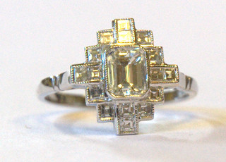 A lady's modern Art Deco style 18ct white gold dress ring set a rectangular cut diamond to the centre supported by numerous diamonds, approx 0.90/0.60ct