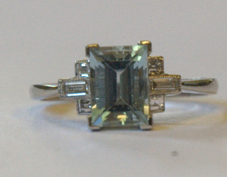 A lady's 18ct white gold dress ring set a rectangular cut aquamarine supported by 2 baguette cut diamonds and 2 circular cut diamonds