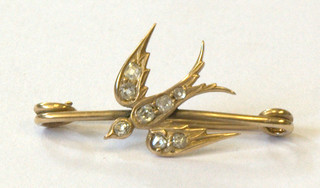 A gold bar brooch in the form of a dove, the wings set diamonds