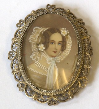 A silver filigree brooch/pendant decorated an ivory portrait miniature of a bonnetted lady