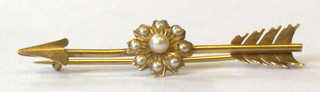 A gold bar brooch in the form of an arrow set demi-pearls