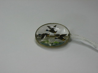 An oval intaglio cut rock crystal brooch decorated flying ducks