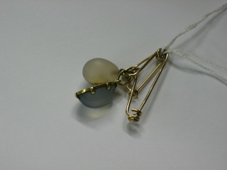 An Edwardian "gold" bar brooch set a cabouchon cut moonstone and 1 other set an egg shaped white hardstone