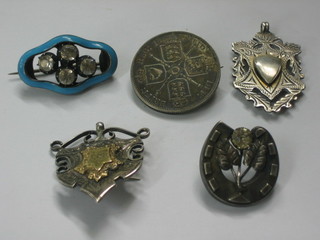 A silver coin brooch, 2 silver brooches, a silver watch chain medallion and a blue enamelled brooch set 3 white stones