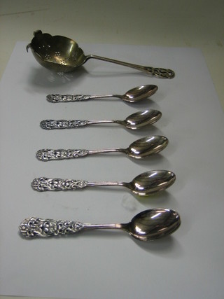 A silver tea strainer and 6 Eastern silver coffee spoons
