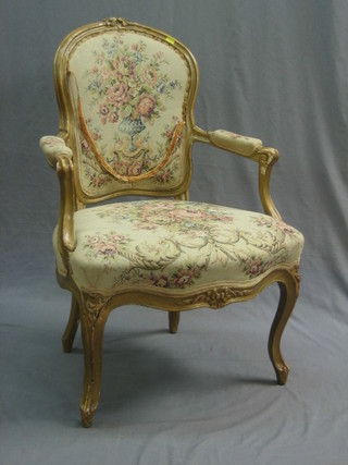 A 19th/20th Century French open arm salon chair upholstered in tapestry material and raised on cabriole supports