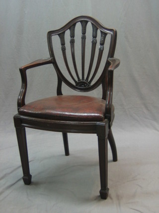 A 19th Century Hepplewhite style mahogany shield back carver chair with upholstered drop in seat, raised on square tapering supports ending in spade feet