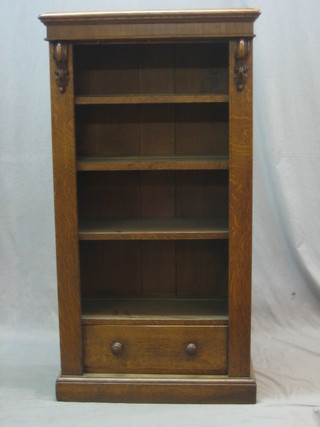A Victorian honey oak open bookcase with adjustable shelves with Vitruvian scroll decoration to the side, the base fitted a drawer 26" (formerly a Wellington chest)