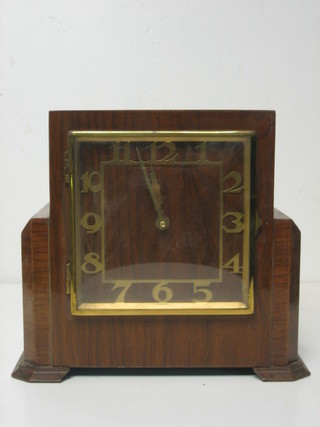 An Art Deco battery operated mantel clock with square dial contained in a walnut case