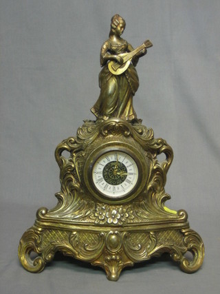 A 1950's mantel clock contained in an ornate gilt metal  case surmounted by a figure of a standing lady