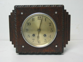 An Art Deco striking mantel clock with silvered dial and Arabic numerals contained in a square oak case