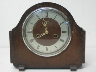 A 1940's striking mantel clock with silvered dial and Roman numerals contained in an oak arch shaped case by Smith Enfield