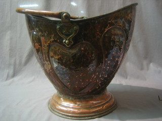 An Art Nouveau embossed copper helmet shaped coal scuttle