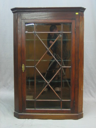 A Georgian mahogany corner cabinet with moulded cornice, the interior fitted adjustable shelves enclosed by astragal glazed panelled doors, 31"
