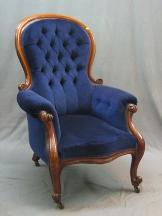 A Victorian mahogany show frame armchair upholstered in blue buttoned material, raised on cabriole supports