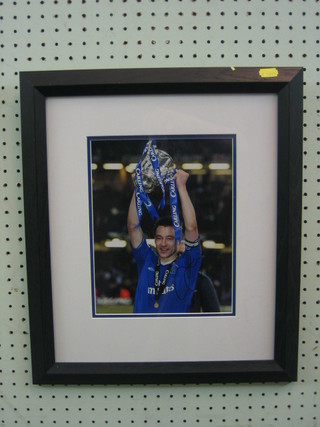 A signed colour photograph of John Terry in blue Chelsea football strip, holding the Carling Cup 9" x 8", with certificate of authenticity