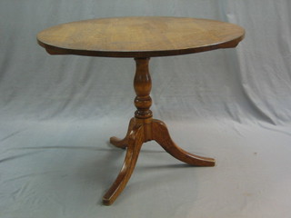 A 19th Century circular oak snap top tea table, raised on a turned column and tripod 38 1/2"