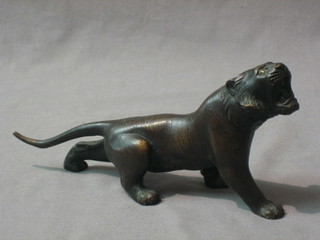 A 19th Century Japanese bronze figure of a walking lion with hardstone set eyes, the base signed, 7"