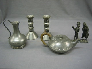 A circular planished pewter teapot, 2 pewter candlesticks 6", a similar jug 6" and 2 pewter figures of The Artful Dodger and Fagin 5"