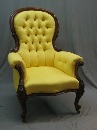 A Victorian mahogany show frame armchair upholstered in yellow buttoned material, raised on cabriole supports