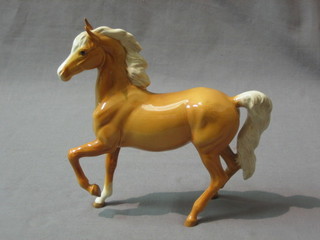 A Beswick figure of a prancing Palomino foal with left hoof crooked, 6 1/2" (back leg f and r)