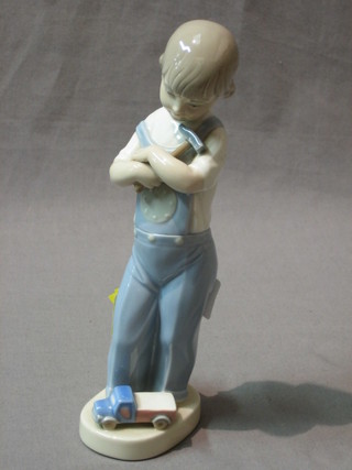 A Lladro figure of a standing boy with hammer and toy car 8"