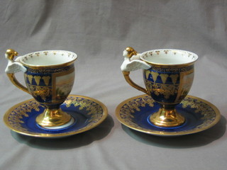 A pair of reproduction Meissen cabinet cups and saucers with blue and gilt banding