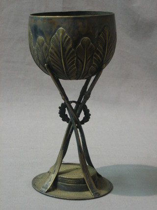 A 19th/20th Century silver plated rowing goblet supported by 4 oars above a boater 8"