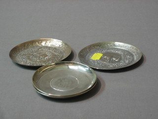 2 circular Eastern embossed silver ashtrays and 2 silver ashtrays inset coins, 7 ozs 