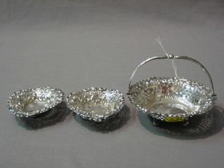 An Edwardian circular pierced silver basket with twin handle, raised on bun feet, Birmingham 1900 4 1/2" and 2 pierced heart shaped silver dishes 2 ozs