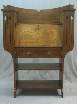 An Edwardian Art Nouveau oak student's bureau with fall front, the pierced sides fitted shelves, 38"