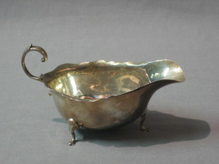 A Georgian style silver sauce boat with cut borders and C scroll handle raised on paw feet, Birmingham 1927, 3 ozs