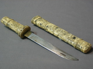 A dagger with 8" blade contained in a carved ivory sheath