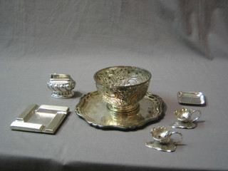 A circular silver plated salver with bracketed border 8", 2 Art Deco silver plated ashtrays 4" and do. embossed bowl, a table lighter and 4 Eastern chamber sticks