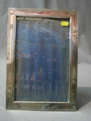 A rectangular silver easel photograph frame 13" x 9", marks rubbed, some dents