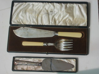 A silver handled cake slice and a pair of silver plated fish servers