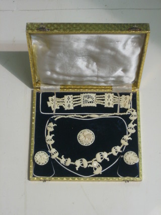 A suite of ivory jewellery comprising necklace, brooch, 2 ear clips and a bracelet, cased