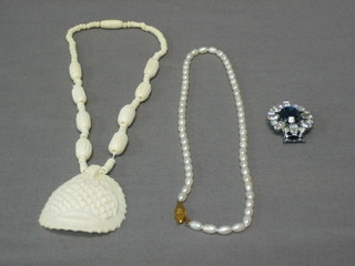 A string of freshwater pearls, an ivory pendant, a string of ivory beads and a diamonte bracelet and choker clip