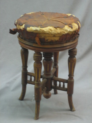 An Edwardian walnut piano stool, raised on turned and fluted supports