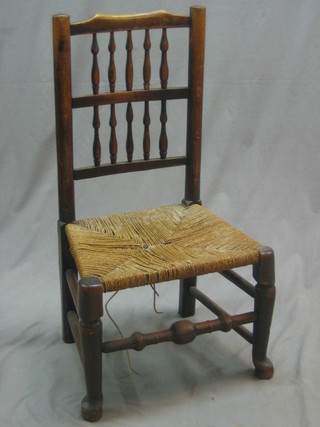 An elm stick and rail back chair with bobbin turned decoration and woven seat