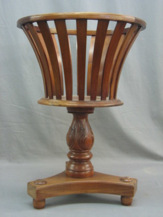 A Georgian style circular mahogany waisted wall basket, raised on a turned column with triform base