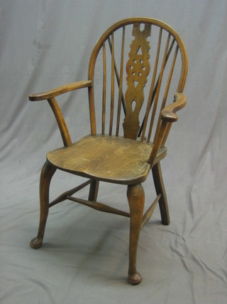A 20th Century elm stick and wheel back kitchen carver chair with solid elm seat, raised on cabriole supports