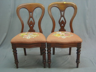 A pair of Victorian mahogany tulip back dining chairs with upholstered seats raised on turned supports