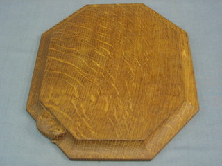 An  octagonal carved oak Mouseman (Thomas) cheese board, 12"