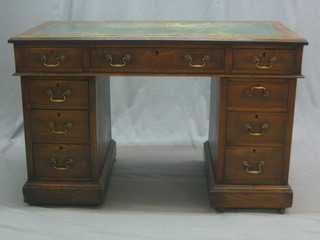 A Victorian oak kneehole pedestal desk with inset tooled leather writing surface, the base fitted 1 long and 8 short drawers 47"