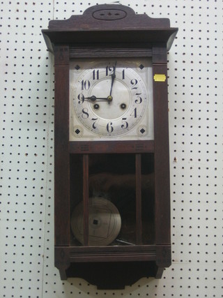 A chiming wall clock with silvered dial and Arabic numerals contained in an oak case