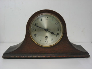 A chiming mantel clock with silvered dial contained in an oak Admirals hat shaped case