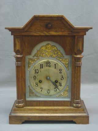 A striking bracket clock with silvered dial and Arabic numerals contained in an oak case