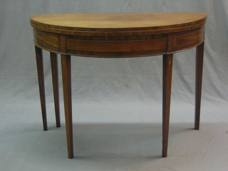 A Georgian mahogany demi-lune card table inlaid satinwood stringing, raised on square tapering supports 39"